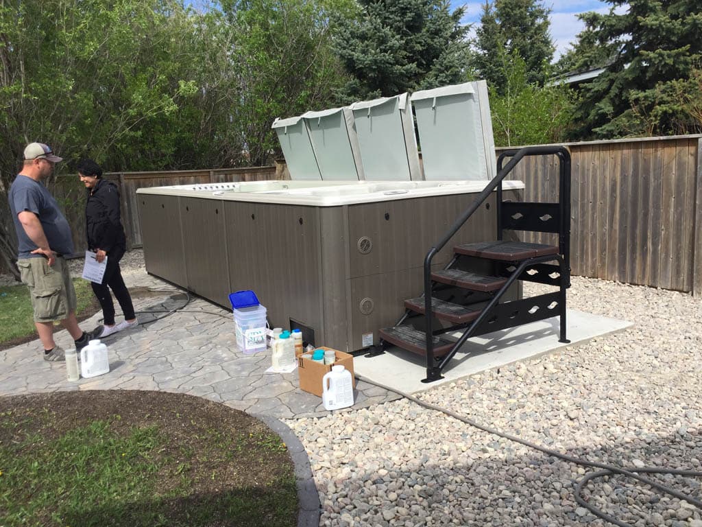Gravel hot tub pad installation with weed barrier and compacted crushed gravel in Ontario